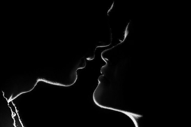 Silhouette of a couple just about to kiss.